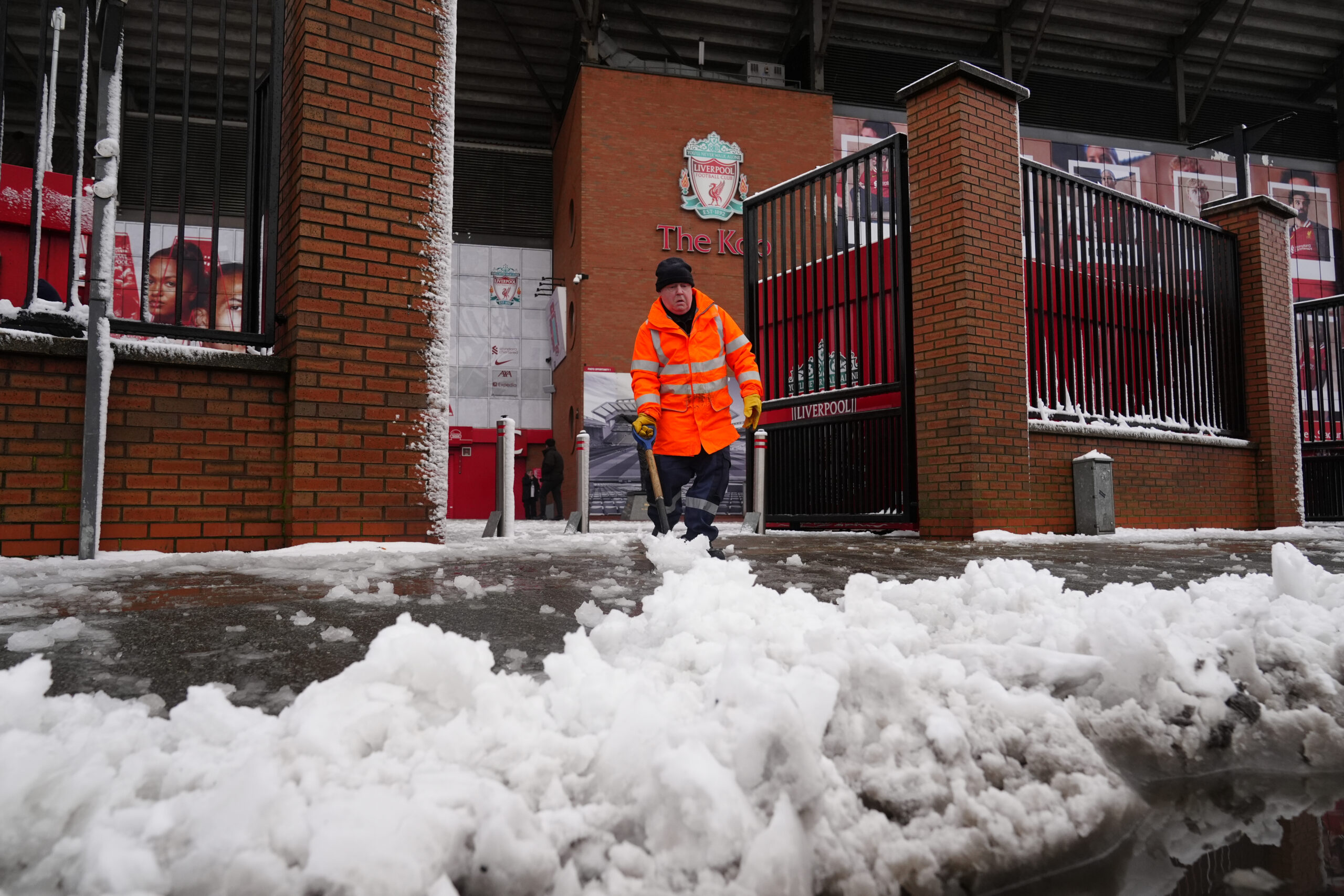 Ein Arbeiter schiebt Schnee vor der Anfield Road