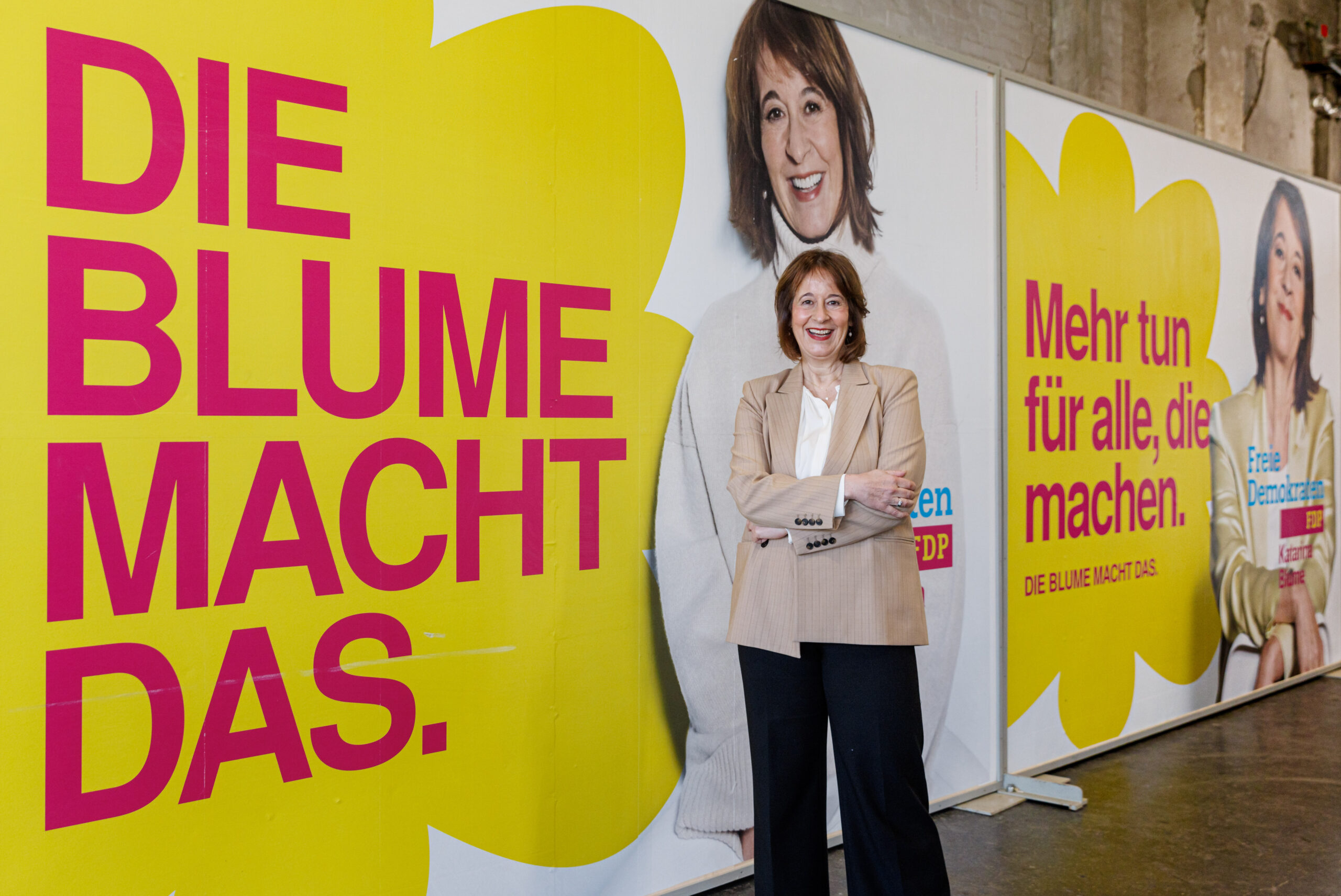 Katarina Blume, Spitzenkandidatin der FDP Hamburg steht vor Kampagnenpostern