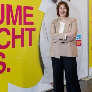 Katarina Blume, Spitzenkandidatin der FDP Hamburg steht vor Kampagnenpostern