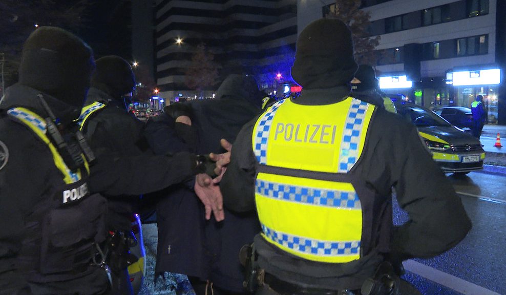 Polizisten nehmen einen Verdächtigen fest. Vorher ist ein Mann durch Schüsse vor einem Lokal am Hamburger Hansaplatz verletzt worden.