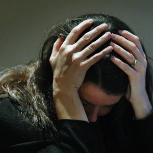 Eine Frau hält ihren Kopf in ihren Händen