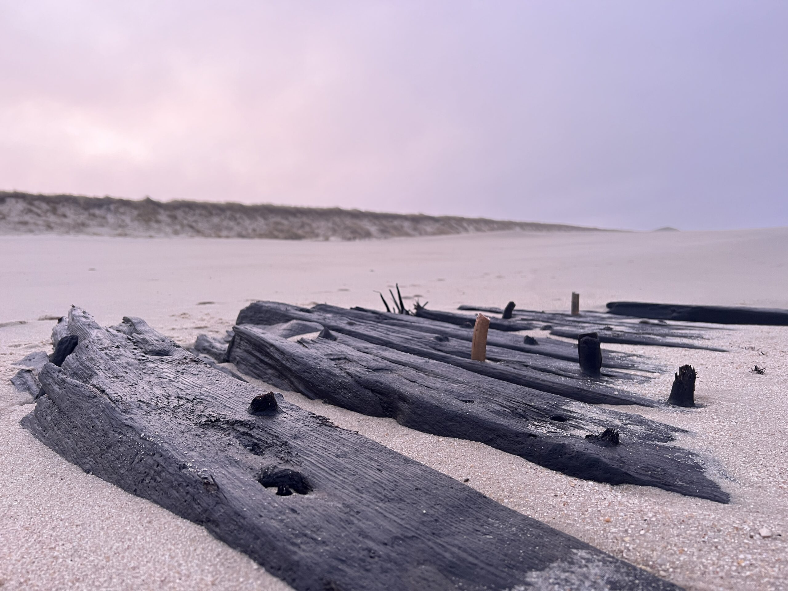 Verwitterte Überreste eines Schiffes liegen bei Ebbe am Strand vor Sylt (Rantum). Experten des Archäologischen Landesamtes Schleswig-Holstein wollen in der kommenden Woche untersuchen, um welchen Schiffstyp es sich handelt und wie alt die Wrackteile sind.