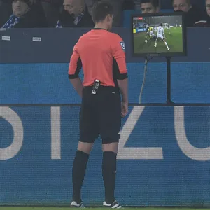 Schiedsrichter guckt sich eine Szene auf dem Monitor an