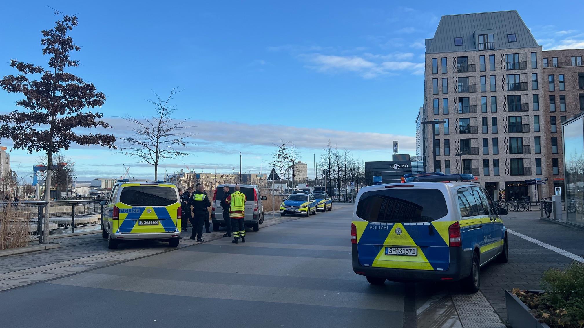 Einsatzfahrzeuge der Polizei stehen am Rande der Kieler Fußgängerzone. Dort wurde ein Mensch bei einer Auseinandersetzung verletzt.