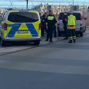 Einsatzfahrzeuge der Polizei stehen am Rande der Kieler Fußgängerzone. Dort wurde ein Mensch bei einer Auseinandersetzung verletzt.