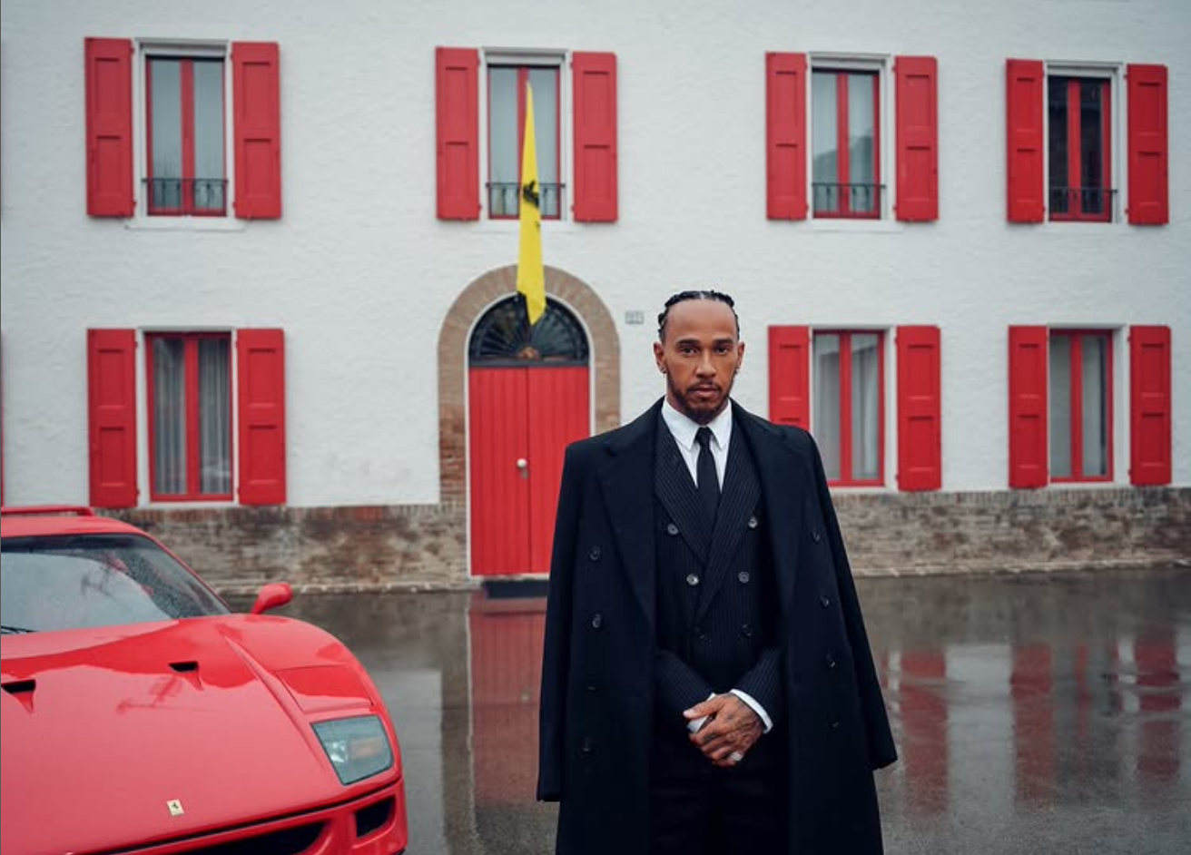 Lewis Hamilton posiert im Anzug vor einem Haus und einem Ferrari