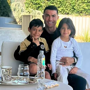 Cristiano Ronaldo sitzt mit zwei seiner Kinder draußen auf einem Sofa