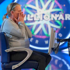 Iris Oberath sitzt, die Hände vor dem Gesicht auf dem „Wer wird Millionär“-Stuhl.