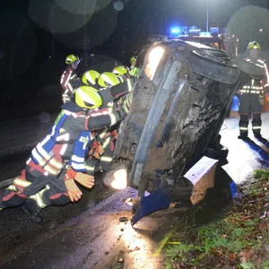 Mit vereinten Kräften kippten Feuerwehrleute den Clio wieder in die Horizontale.