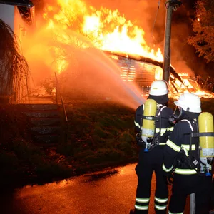 Der Schuppen am Overwerder Bogen in Hamburg-Kirchwerder brannte nieder. Die Kneipe „Hermann's Eck“ (l.) konnten die Feuerwehrleute retten.