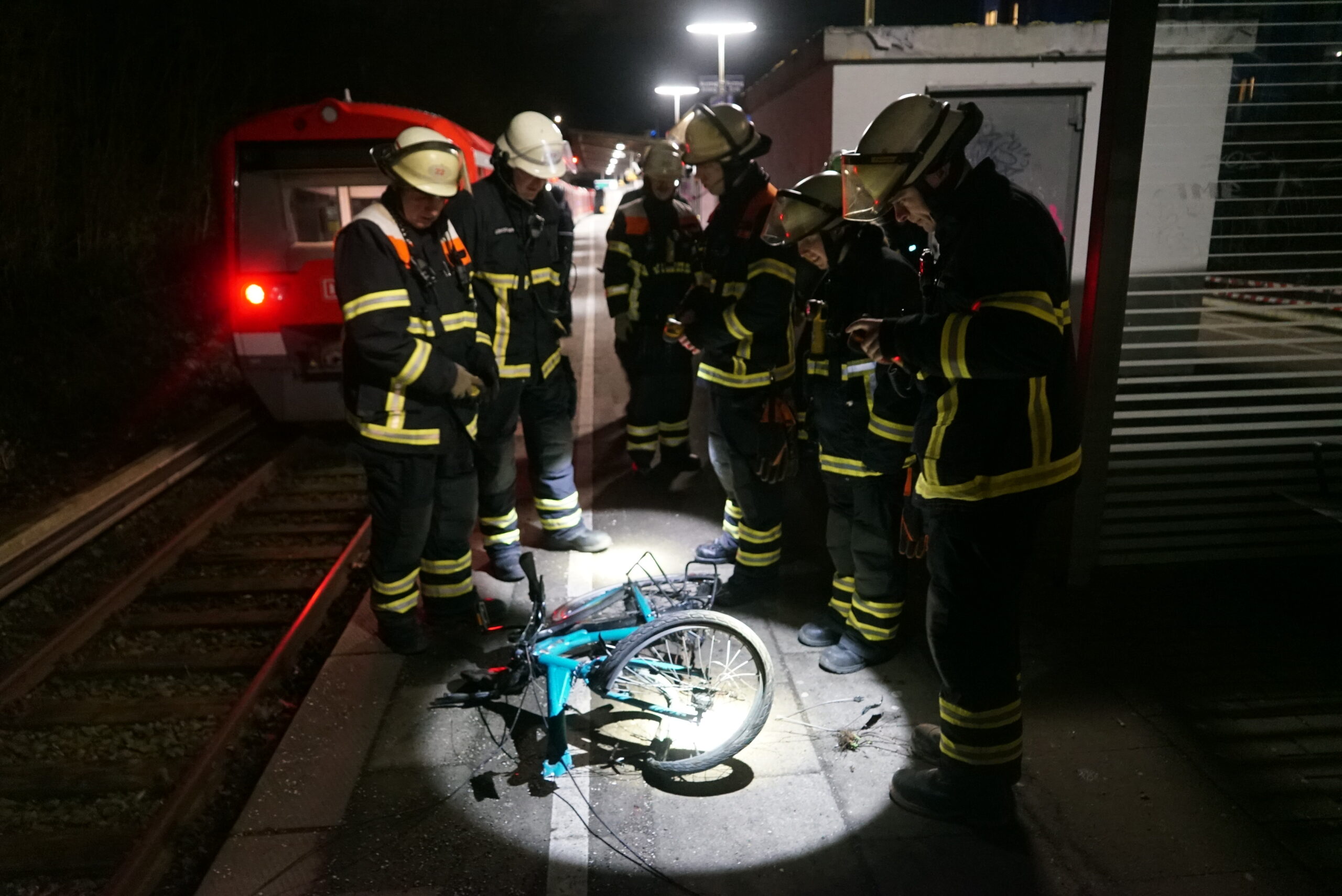 Männer stehen um ein zerstörtes Fahrrad.