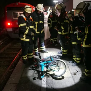 Männer stehen um ein zerstörtes Fahrrad.