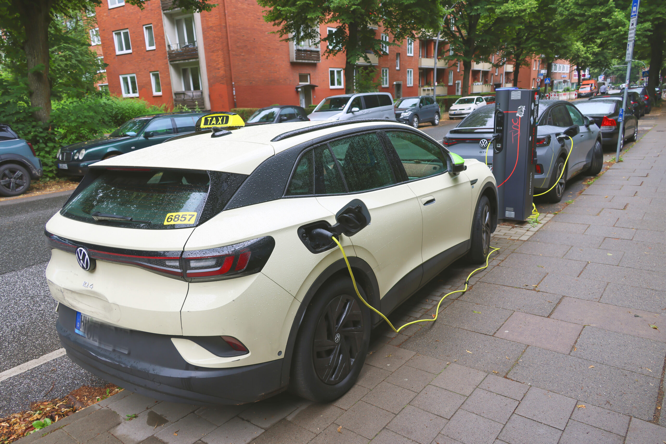 Ein E-Taxi steht an einer Ladesäule.