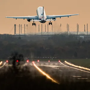 Ein Airbus von Eurowings startet vom Hamburg Airport. Im Hintergrund ist das Volksparkstadion zu sehen.