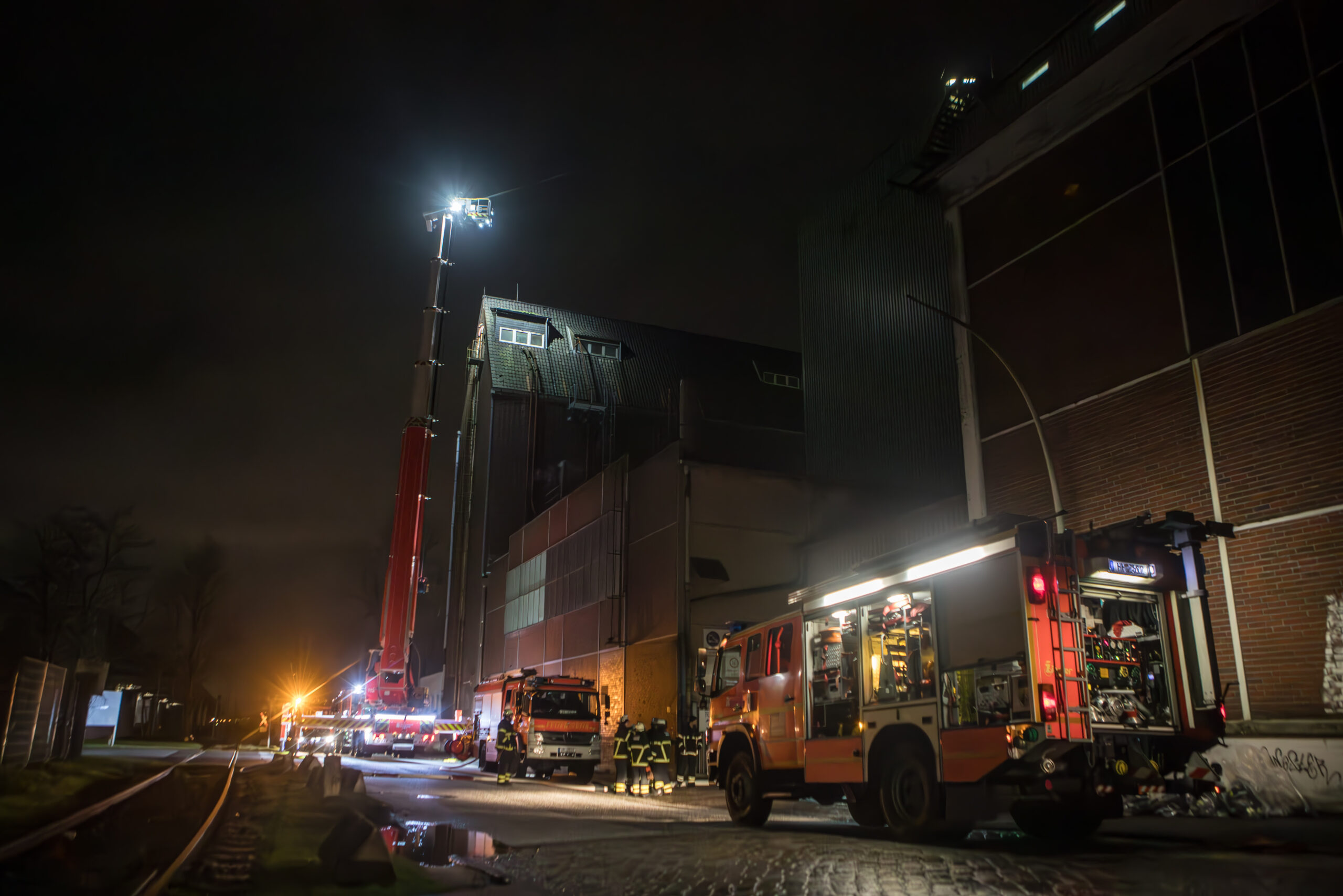 Löschfahrzeuge im Einsatz an einem brennenden Silo im Hafen