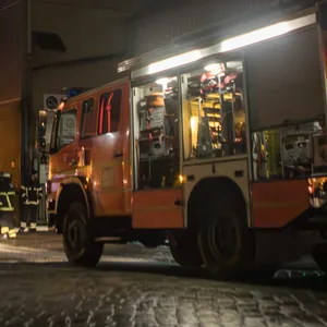Löschfahrzeuge im Einsatz an einem brennenden Silo im Hafen