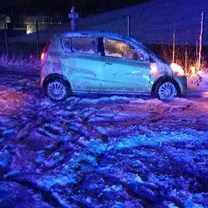 Ein Auto steht auf einer verschneiten Straße.