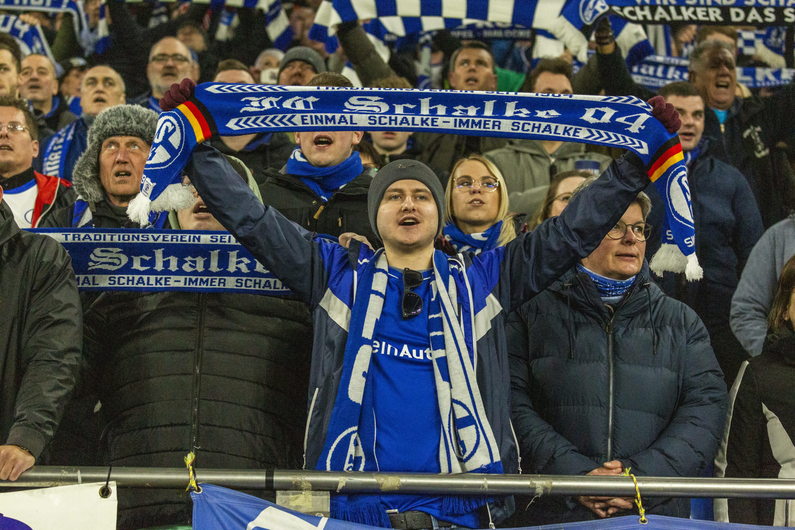 Schalke-Fans singen und halten ihre blau-weißen Schals hoch