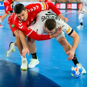 Andy Schmid umklammert Lukas Mertens im Duell um den Ball