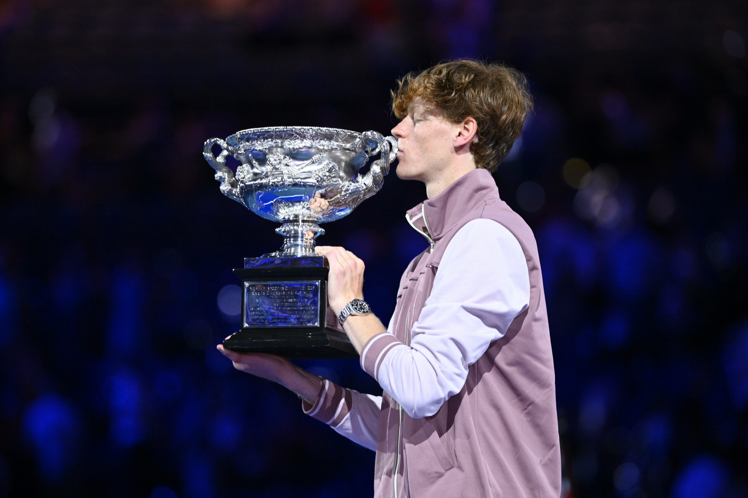 Jannik Sinner küsst nach seinem Sieg bei den Australian Open die Siegertrophäe