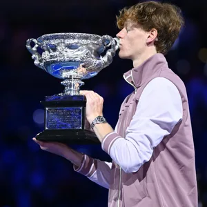 Jannik Sinner küsst nach seinem Sieg bei den Australian Open die Siegertrophäe