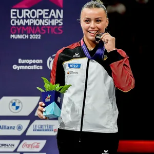 Emma Malewski beißt in ihre Goldmedaille