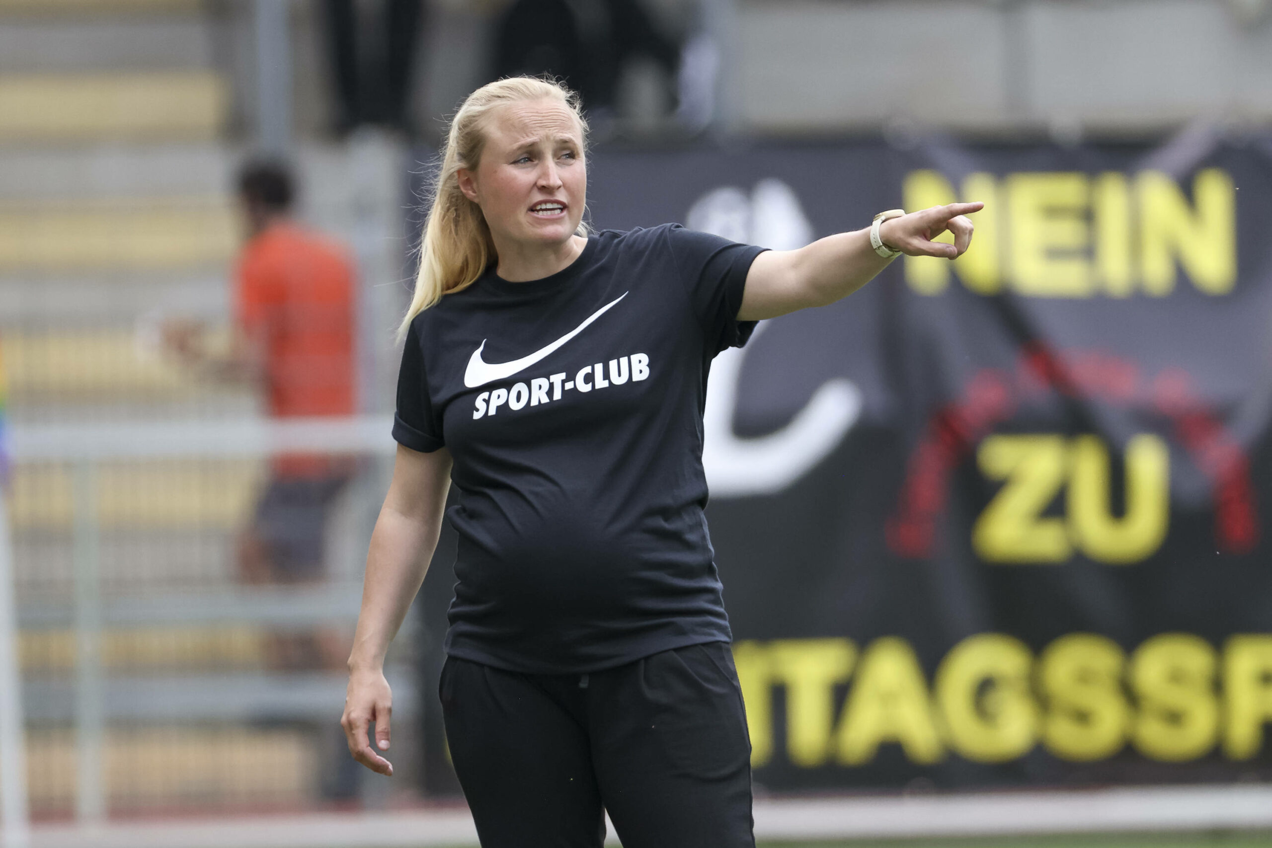 Theresa Merk mit Babybauch am Coachen an der Seitenlinie