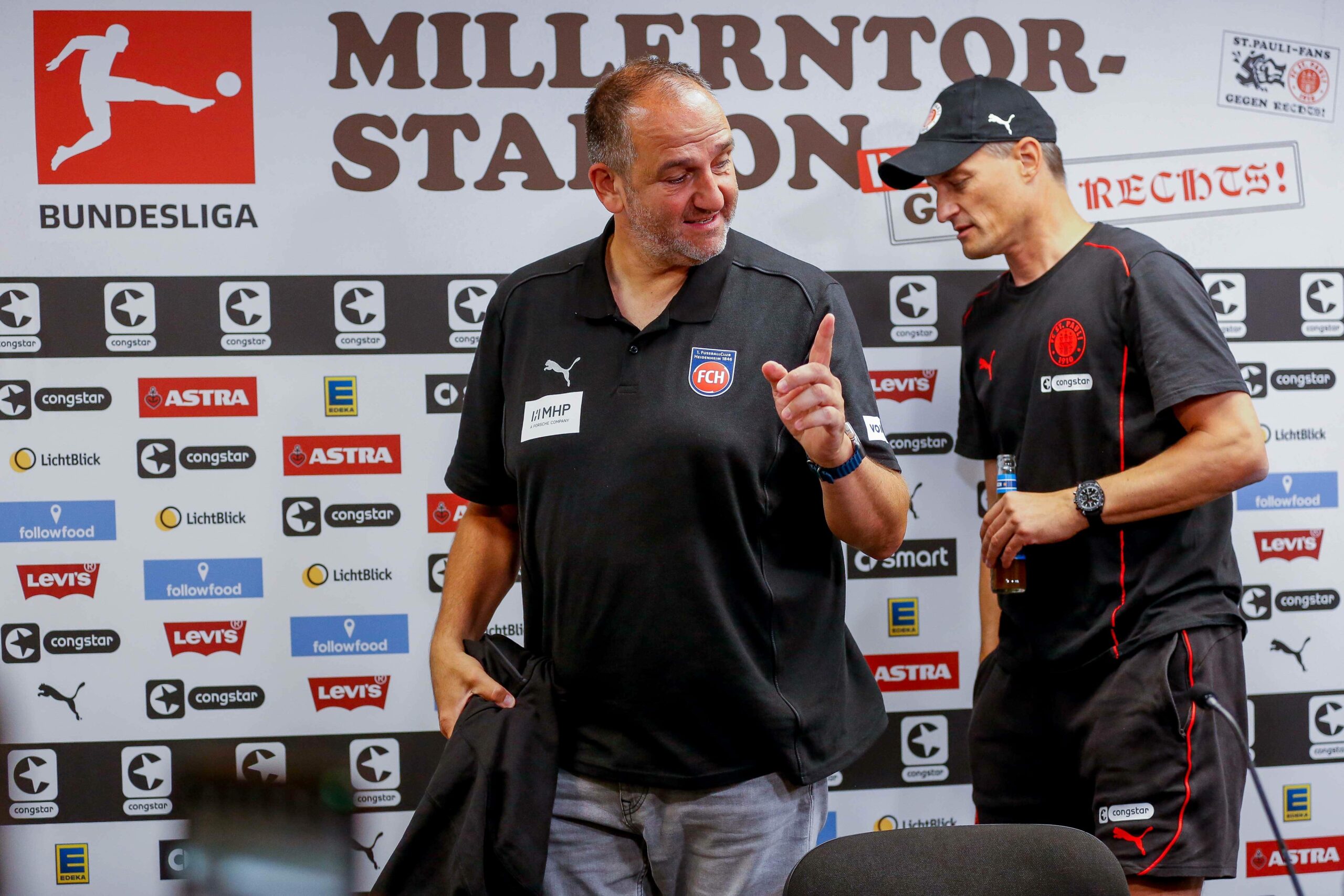 Frank Schmidt und Alexander Blessin witzeln nach der Pressekonferenz nach dem Spiel zwischen St. Pauli und Heidenheim am Millerntor.