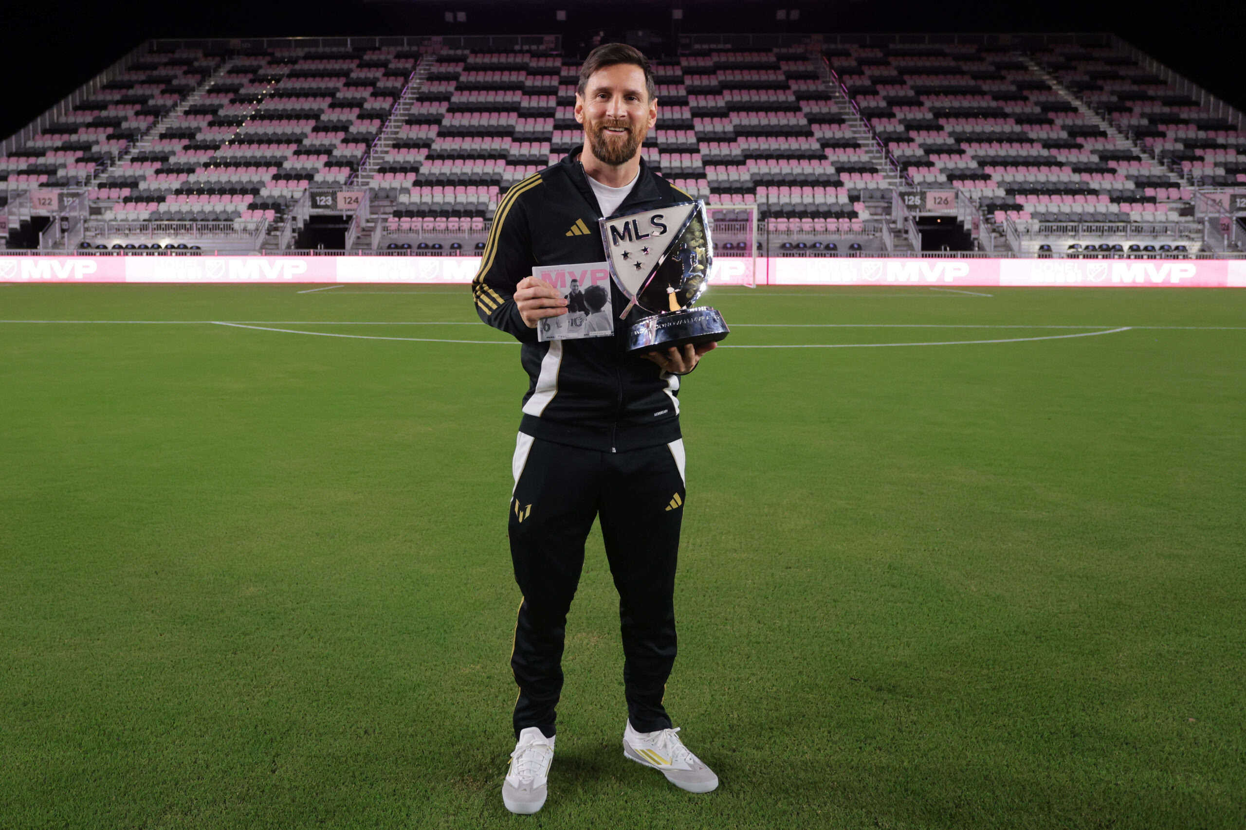 Lionel Messi schaut mit Trophäen in die Kamera