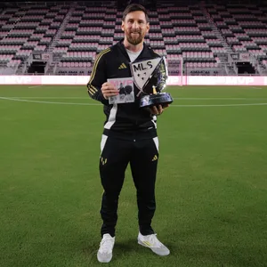 Lionel Messi schaut mit Trophäen in die Kamera