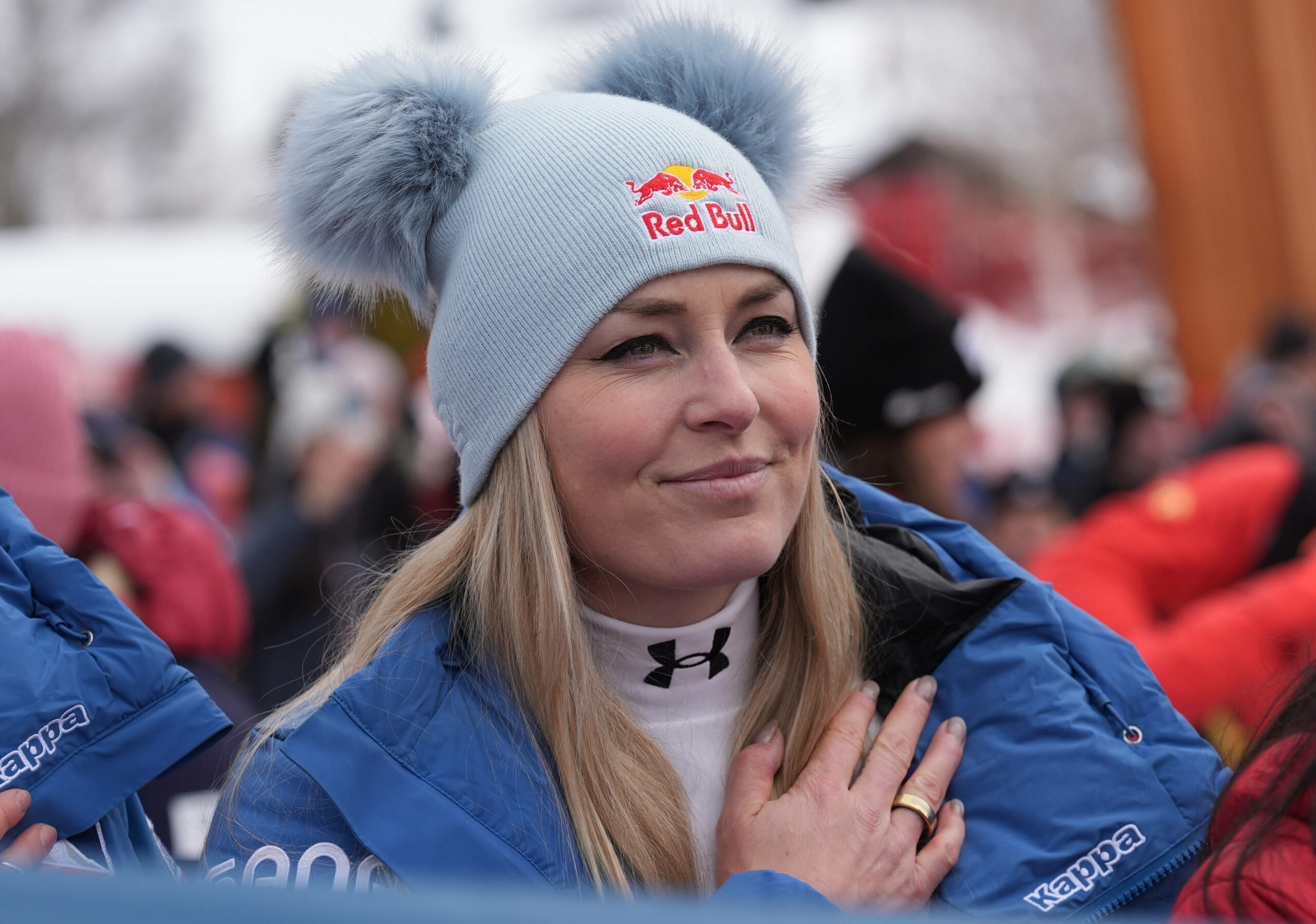 Lindsay Vonn hält sich die Hand aufs Herz und lächelt mit Mütze auf dem Kopf.