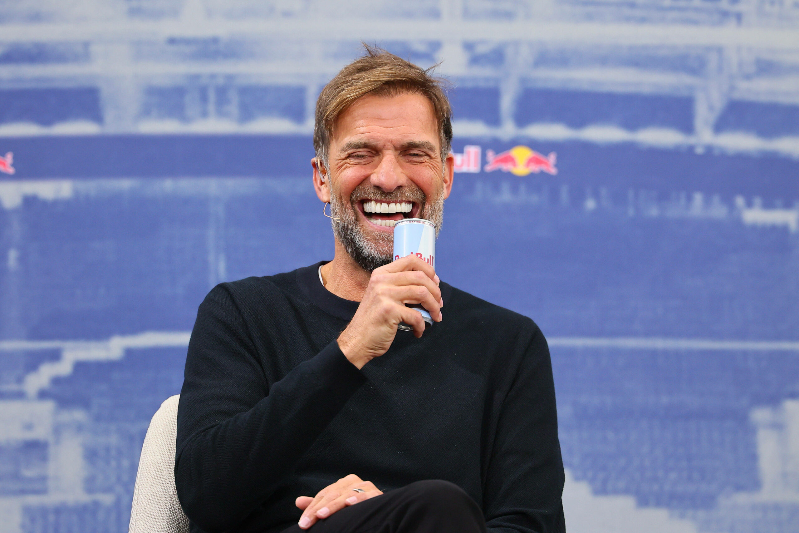 Jürgen Klopp lacht bei seiner Vorstellung mit einer Red Bull in der Hand