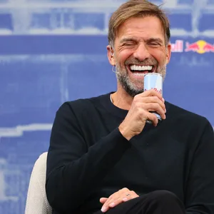 Jürgen Klopp lacht bei seiner Vorstellung mit einer Red Bull in der Hand