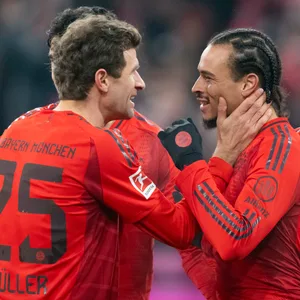 Thomas Müller und Leroy Sané schauen sich gut gelaunt in die Augen beim Torjubel