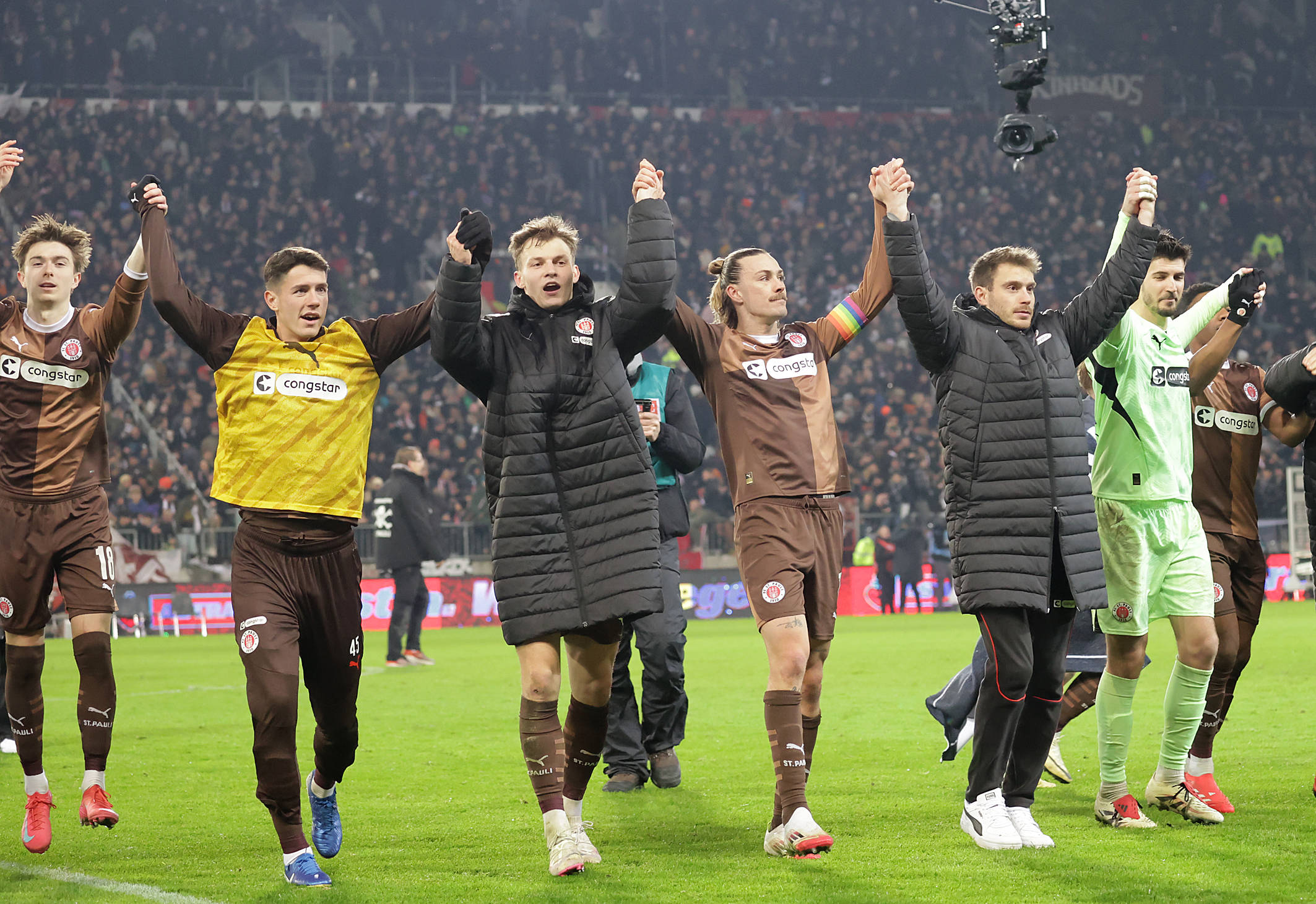 St. Paulis Profis feiern nach dem Sieg gegen Union Berlin vor ihren Fans.