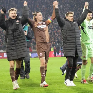 St. Paulis Profis feiern nach dem Sieg gegen Union Berlin vor ihren Fans.