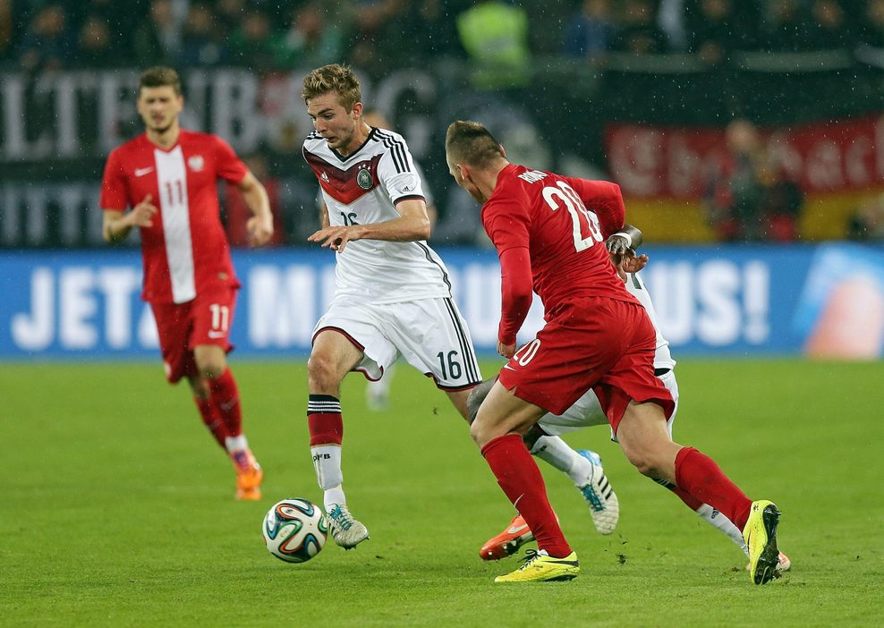 Christoph Kramer dribbelt im DFB-Trikot gegen Polen um Mateusz Klich