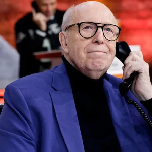 Reiner Calmund hat ein Blaues Sakko an und telefoniert
