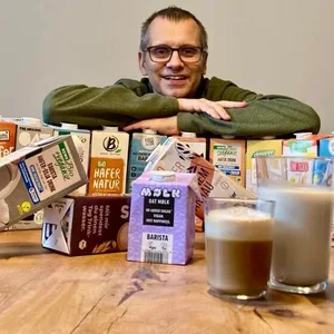 Ein Mann mit verschiedenen Sorten Hafermilch