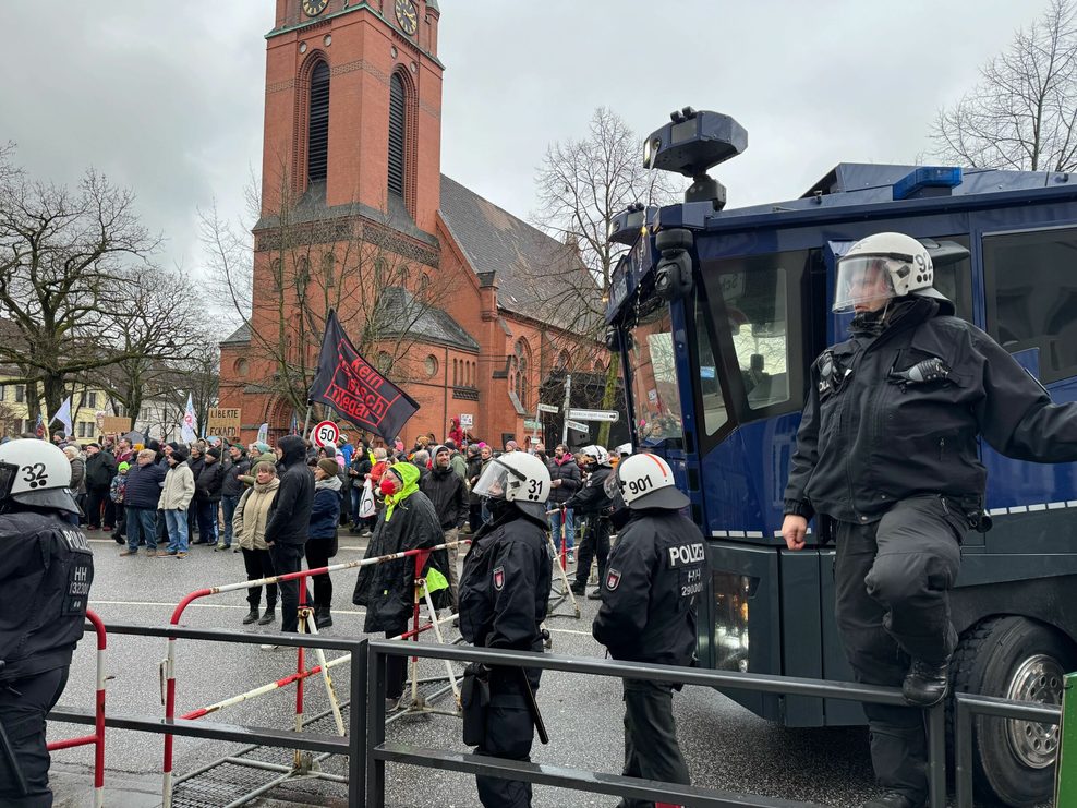 Die Polizei bringt einen Wasserwerfer in Stellung.