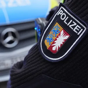 Ein Beamter der Polizei Schleswig-Holstein steht vor einem Einsatzfahrzeug.