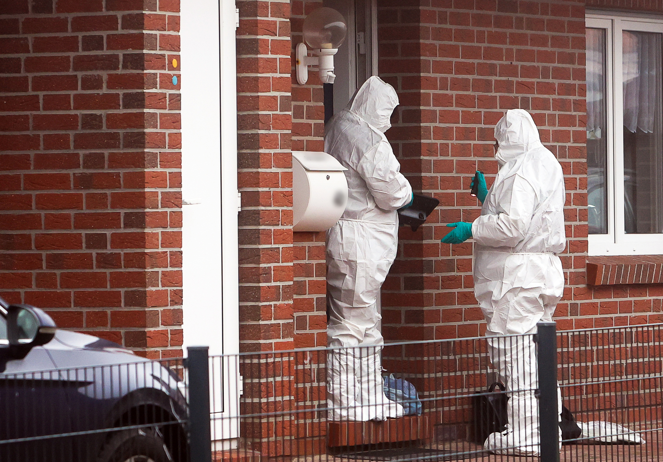 Beamte der Spurensicherung stehen vor dem Einfamilienhaus im Emdener Stadtteil Larrelt.