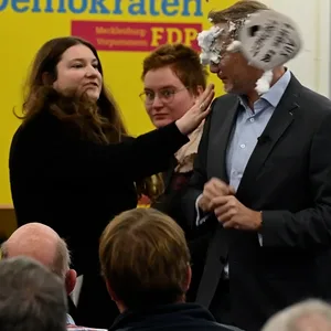 Attacke: FDP-Spitzenkandidat Lindner bekommt von einer Politikerin der Linken eine Ladung Schaum ins Gesicht.