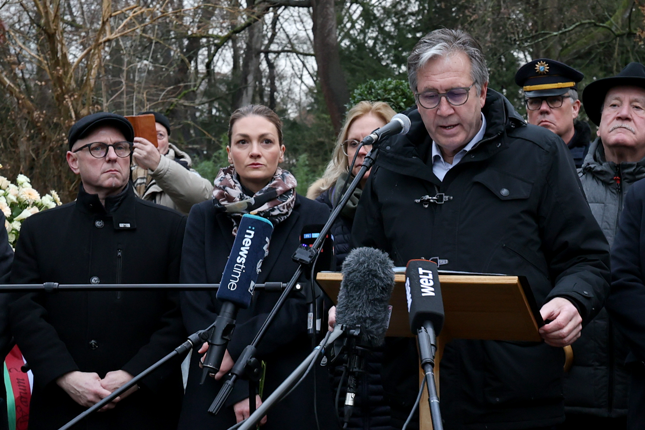 Jürgen Herzing (SPD, rechts vorn), Oberbürgermeister von Aschaffenburg, spricht bei der Kranzniederlegung nach dem tödlichen Angriff in einem Park.