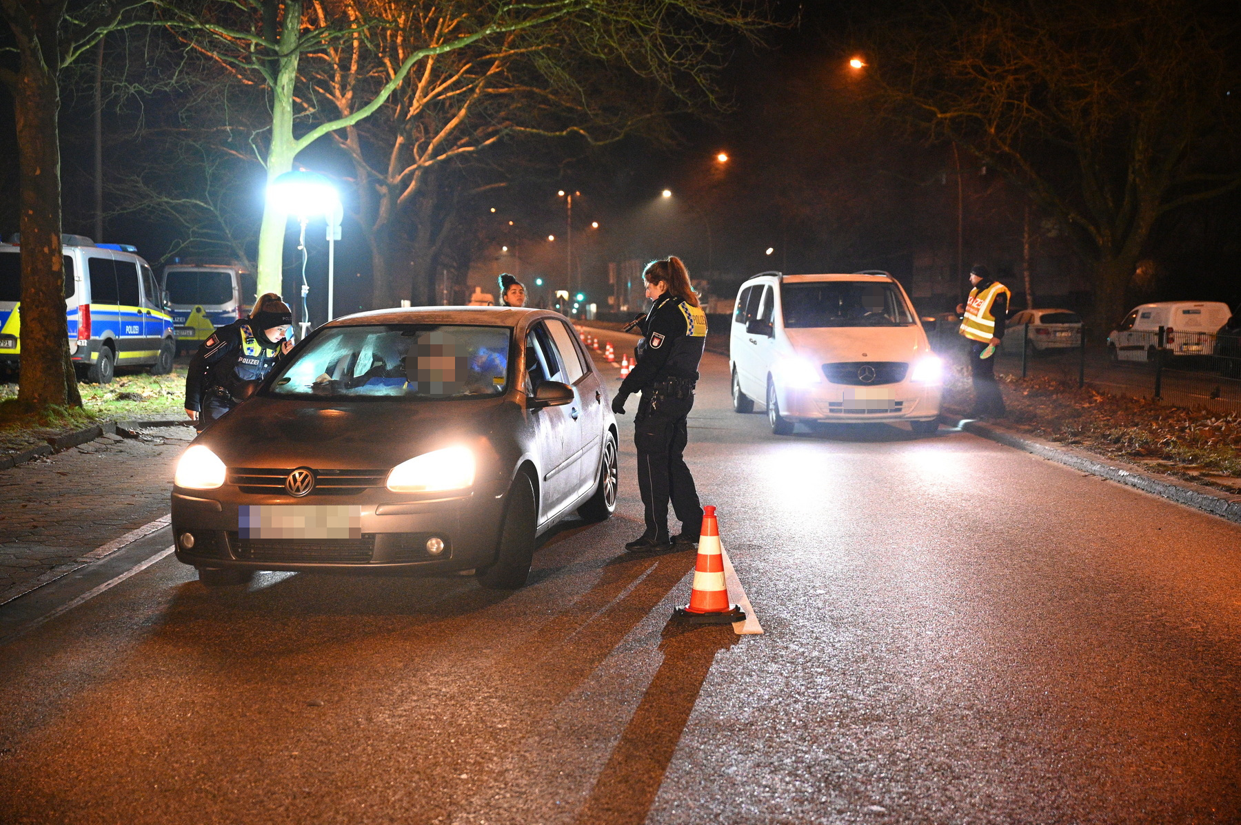 Polizisten kontrollieren zwei Autos auf der Jenfelder Allee.