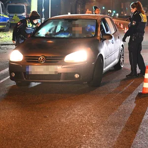 Polizisten kontrollieren zwei Autos auf der Jenfelder Allee.