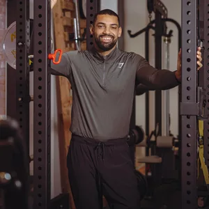 Ein lächelnder Mann zwischen Fitnessgeräten
