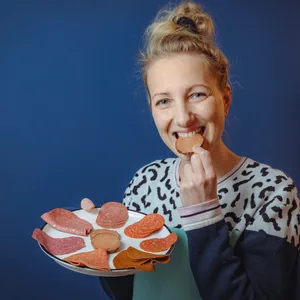 Frau beißt in Salami-Scheibe