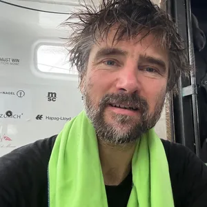 Boris Herrmann macht mit Handtuch und nassen Haaren ein Selfie