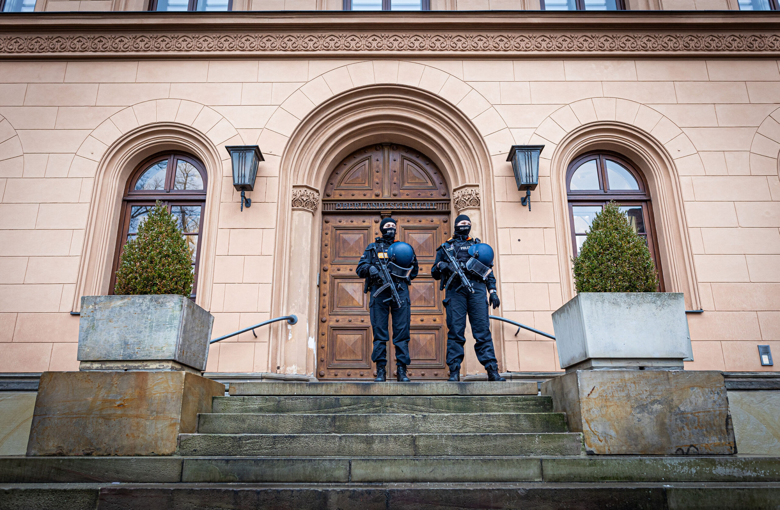 Einsatzkräfte der Polizei stehen vor dem Oberlandesgericht Celle